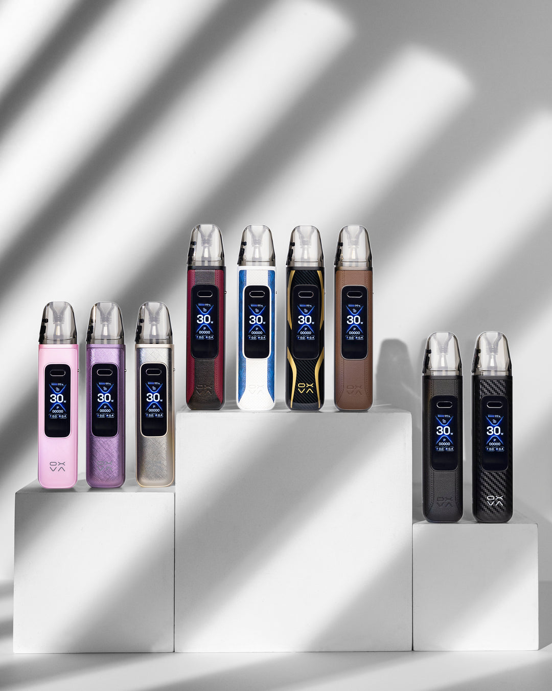 Row of oxva electronic devices on a white platform with a light gray background